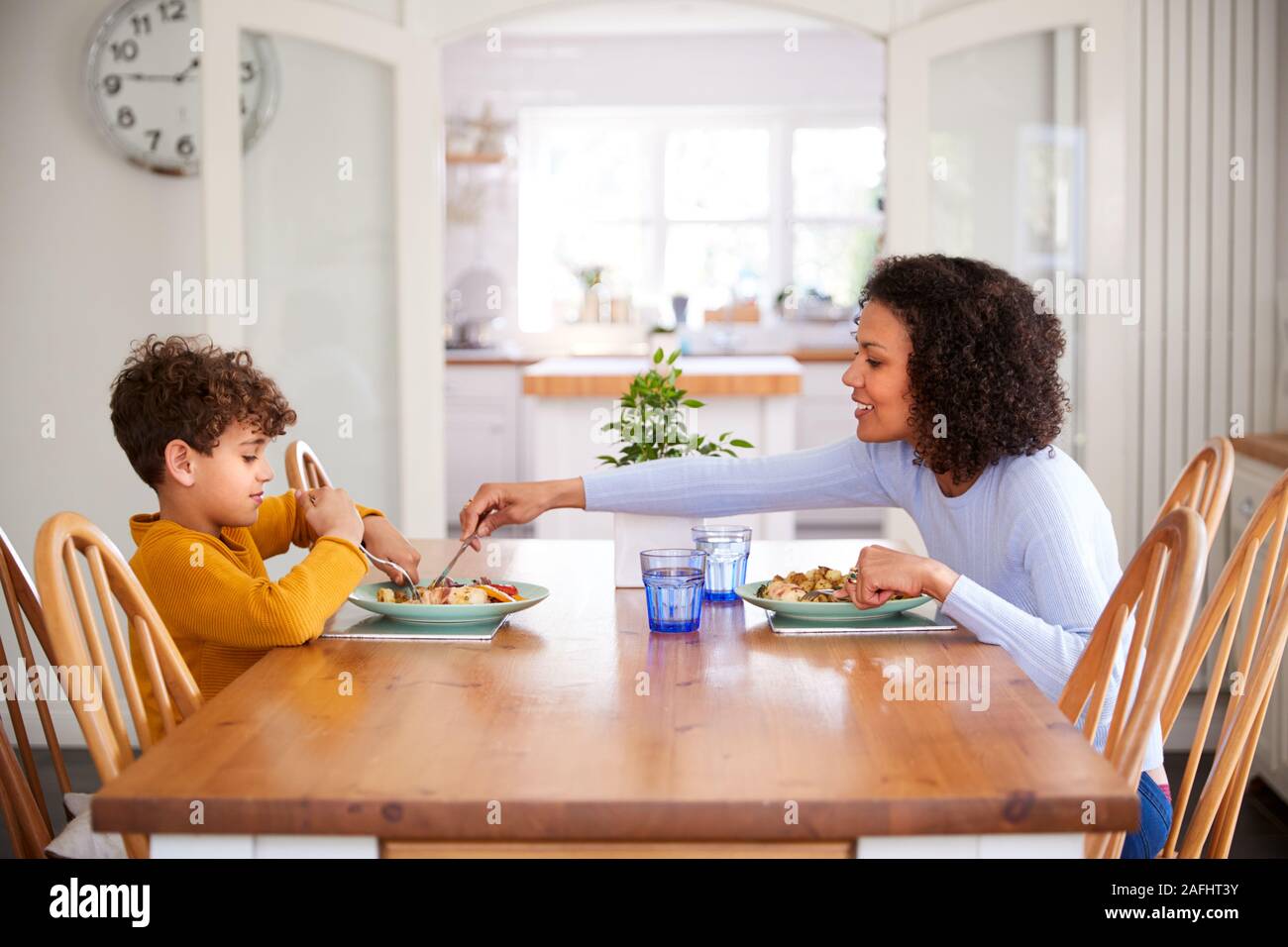 https://c8.alamy.com/comp/2AFHT3Y/single-mother-sitting-at-table-eating-meal-with-son-in-kitchen-at-home-2AFHT3Y.jpg