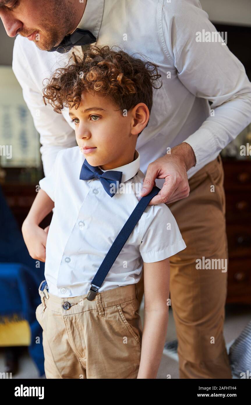 Father And Son Wearing Matching Outfits Getting Ready For Wedding At Home Stock Photo