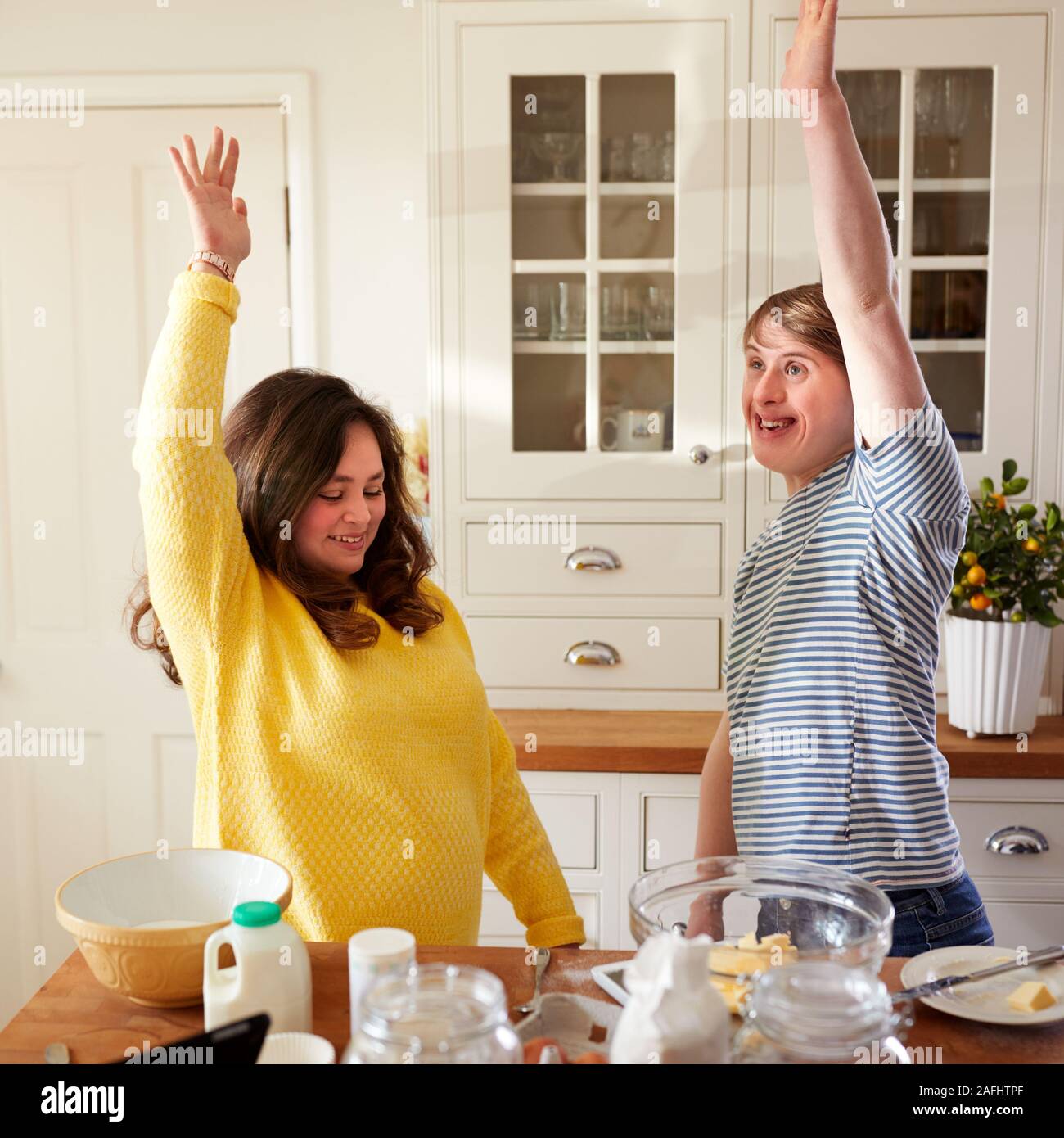 Young Downs Syndrome Couple Having Fun Baking In Kitchen At Home Stock Photo