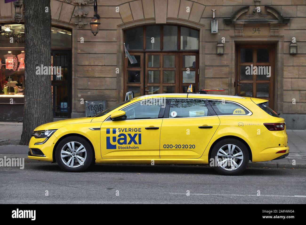 STOCKHOLM, SWEDEN - AUGUST 22, 2018: Yellow Renault Talisman taxi cab in Stockholm. Taxi service market in Sweden is relatively liberal. Stock Photo