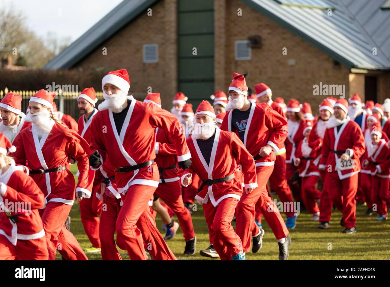 Oxfordshire, UK - December 14th 2019: People dressed as Father Christmas take part in the annual santa fun run. Stock Photo