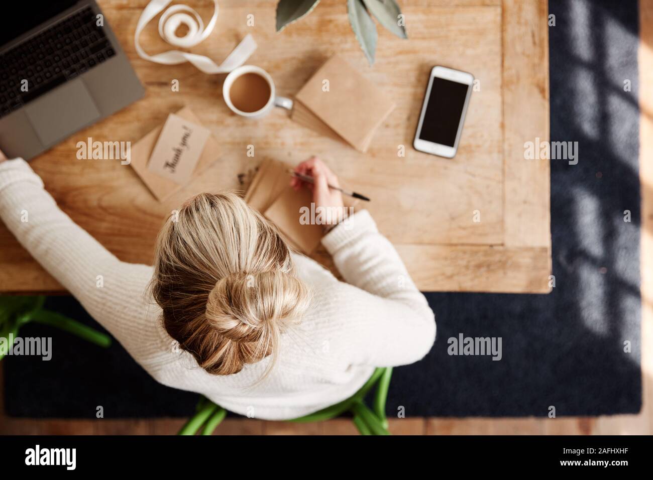 Overhead Shot Looking Down On Woman Writing In Generic Thank You Card Stock Photo