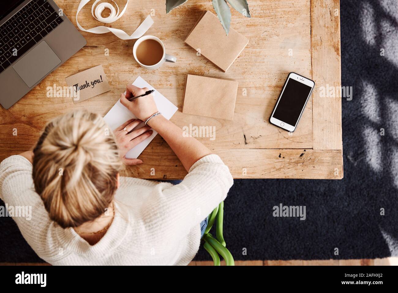 Overhead Shot Looking Down On Woman Writing In Generic Thank You Card Stock Photo