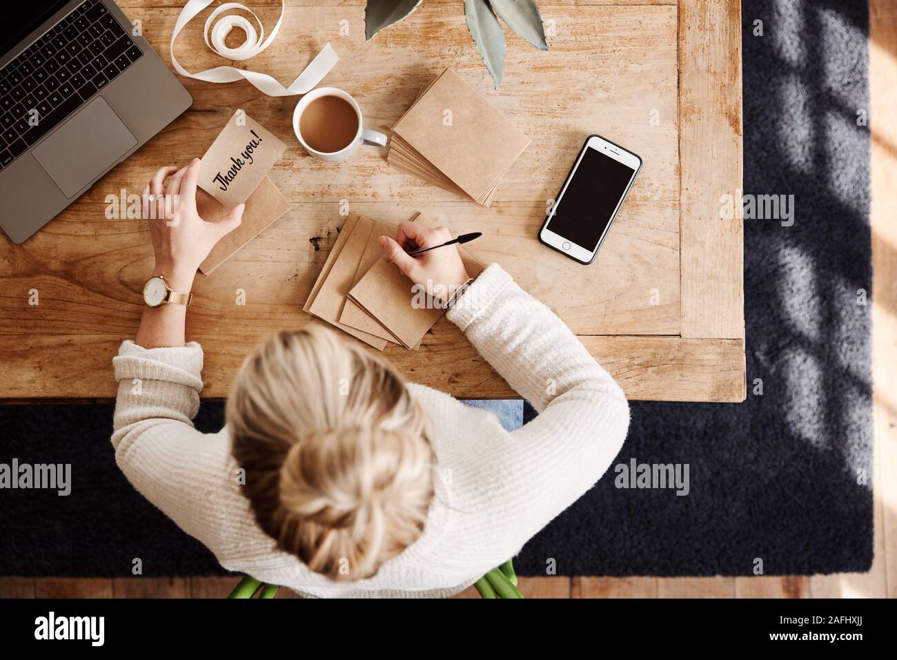 Overhead Shot Looking Down On Woman Writing In Generic Thank You Card Stock Photo