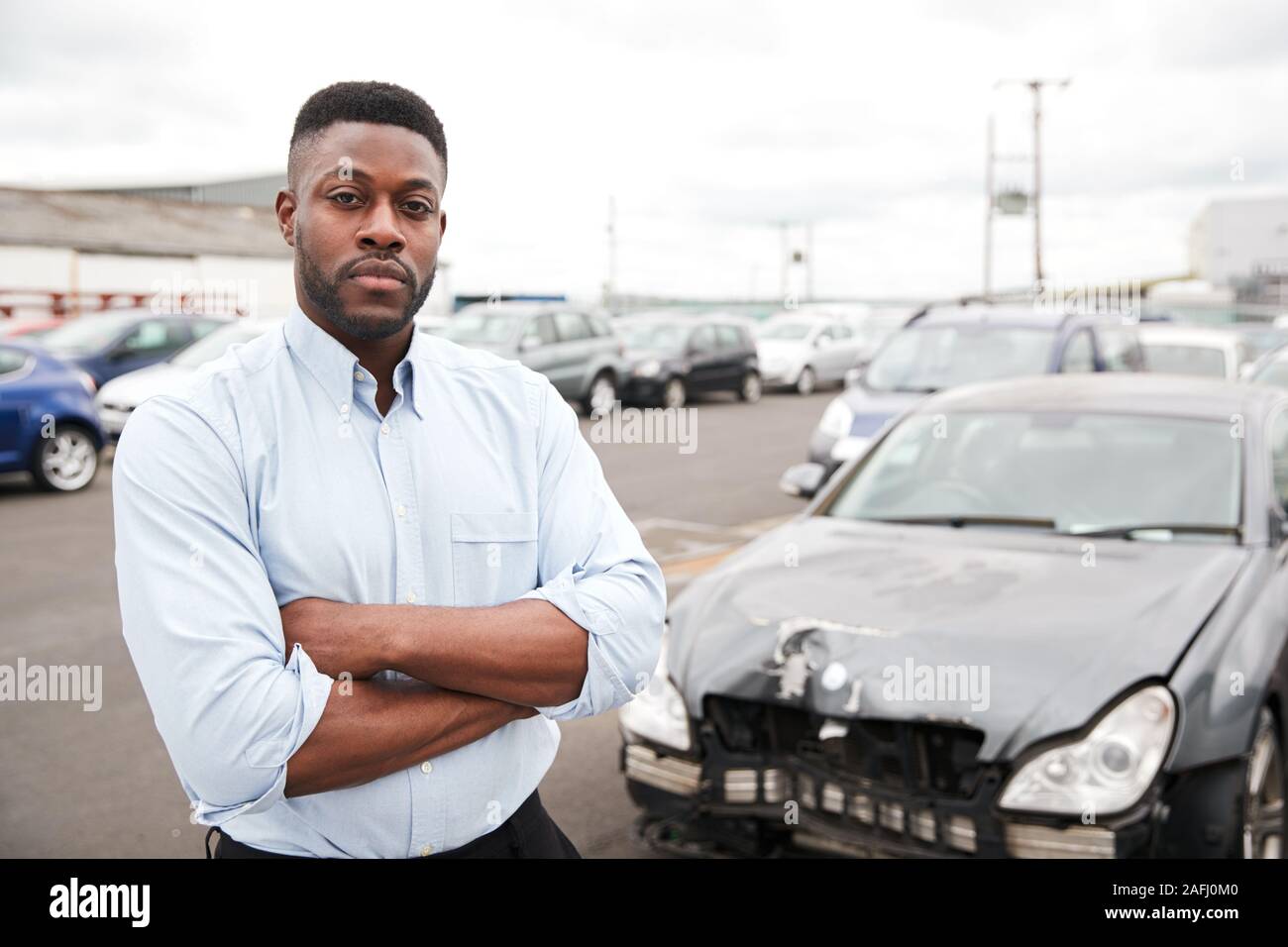 Portrait Of Motorist Standing Next To Car Damaged In Motor Accident Stock Photo