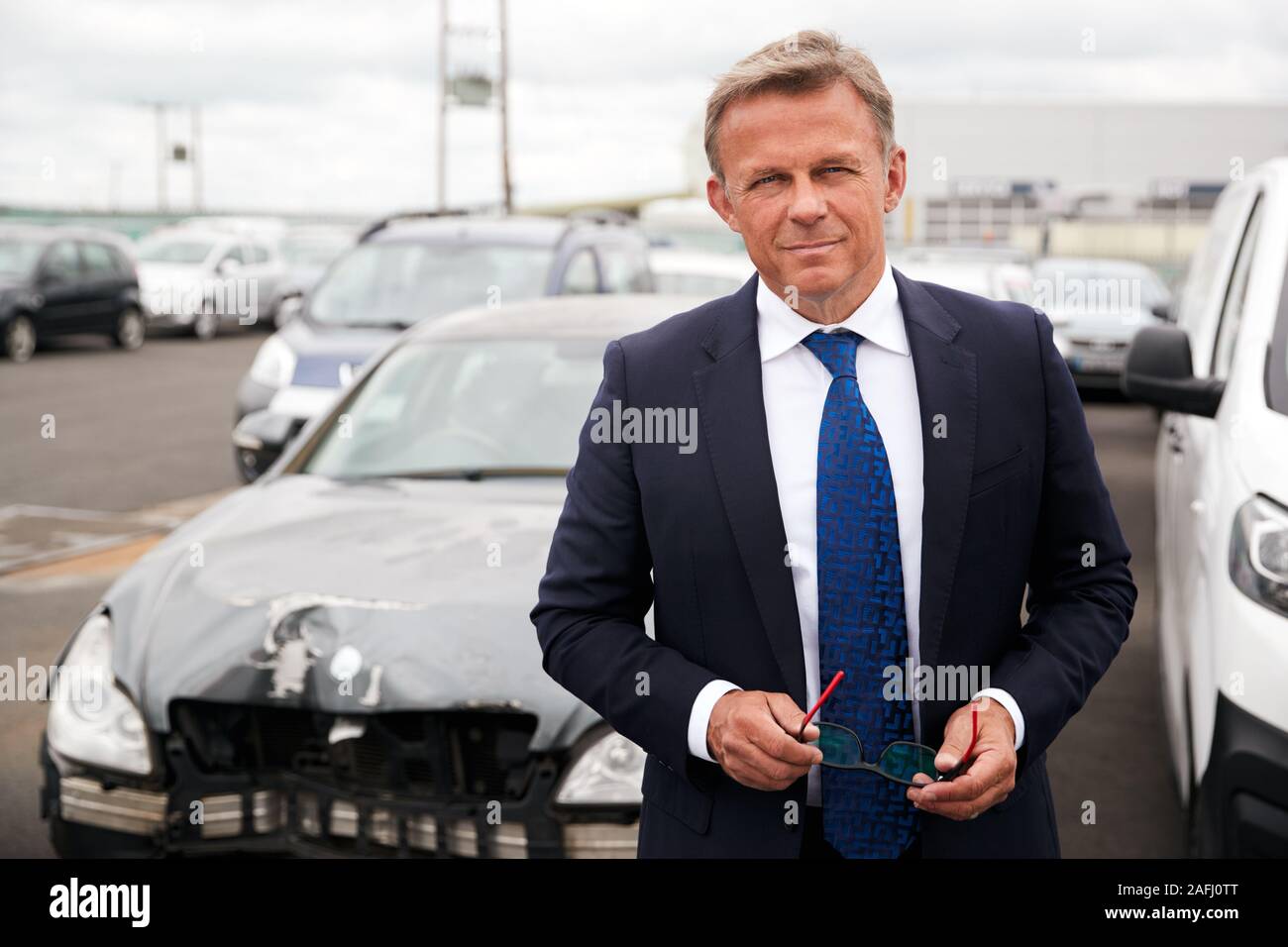 Portrait Of Insurance Loss Adjuster Inspecting Damage To Car From Motor Accident Stock Photo