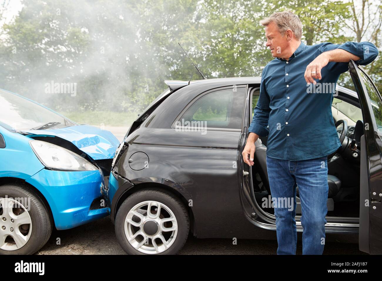 Mature Male Motorist In Crash For Crash Insurance Fraud Getting Out Of Car Stock Photo