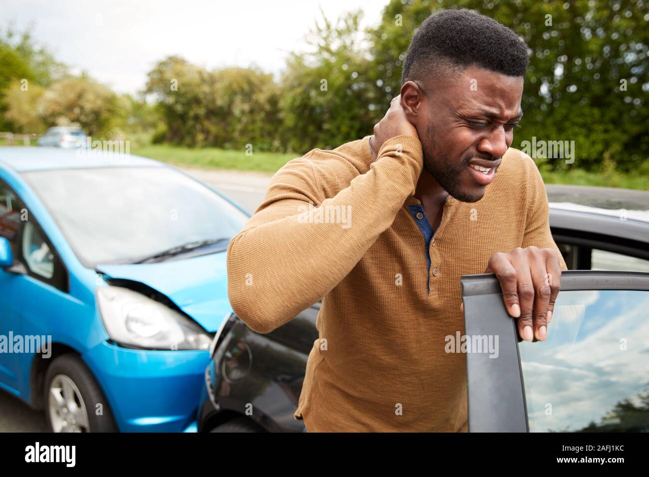 Male Motorist With Whiplash Injury In Car Crash Getting Out Of Vehicle Stock Photo