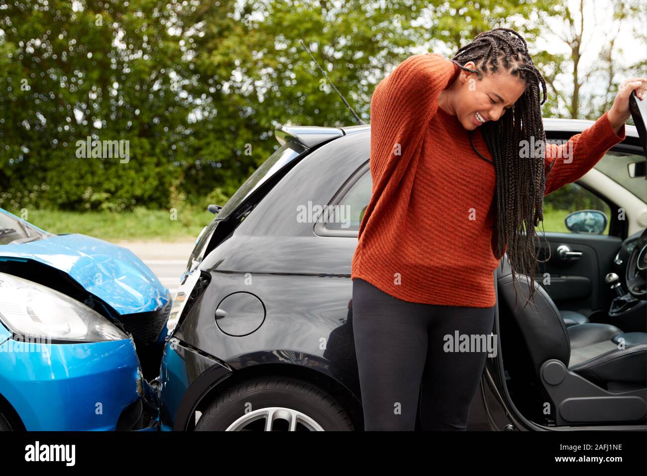 Female Motorist With Whiplash Injury In Car Crash Getting Out Of Vehicle Stock Photo