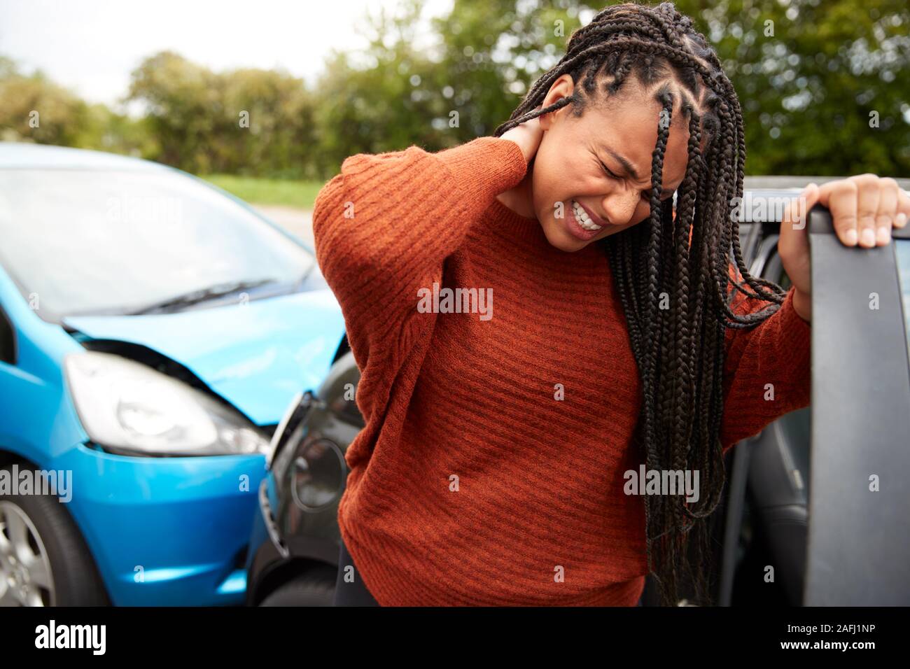 Female Motorist With Whiplash Injury In Car Crash Getting Out Of Vehicle Stock Photo