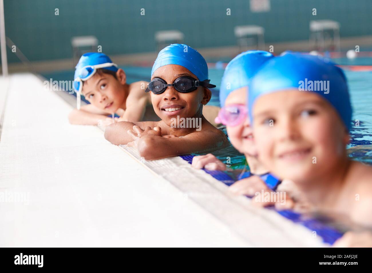 Portrait Of Children In Water At Edge Of Pool Waiting For Swimming ...