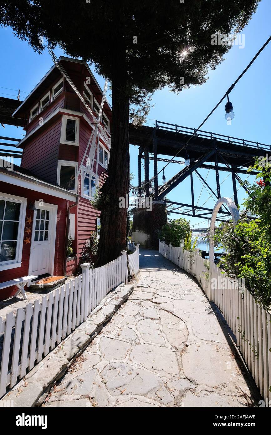 Red wooden house and walkway under the San Lorenzo River railway bridge, Santa Cruz, California, USA Stock Photo