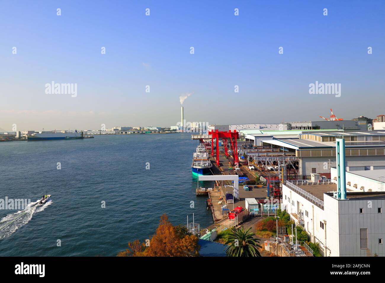 A Cargo Hold Japan Coastal Ship is moored at  Industrial port  surrounded by factory buildings on Osaka Bay,Japan. Stock Photo