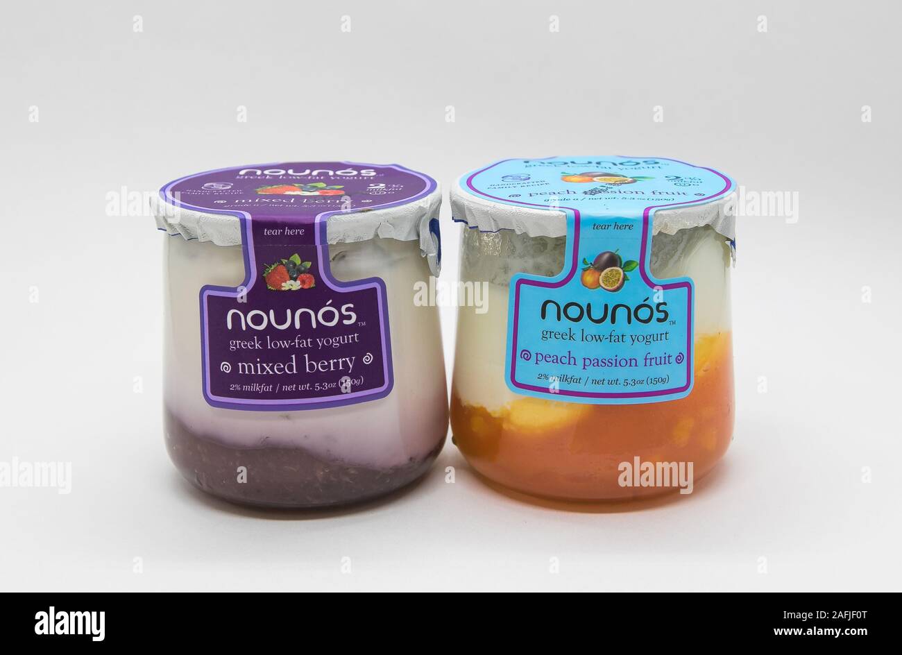 New York, 12/8/2019: Glass containers of Nounos yogurt stand against white background. Stock Photo