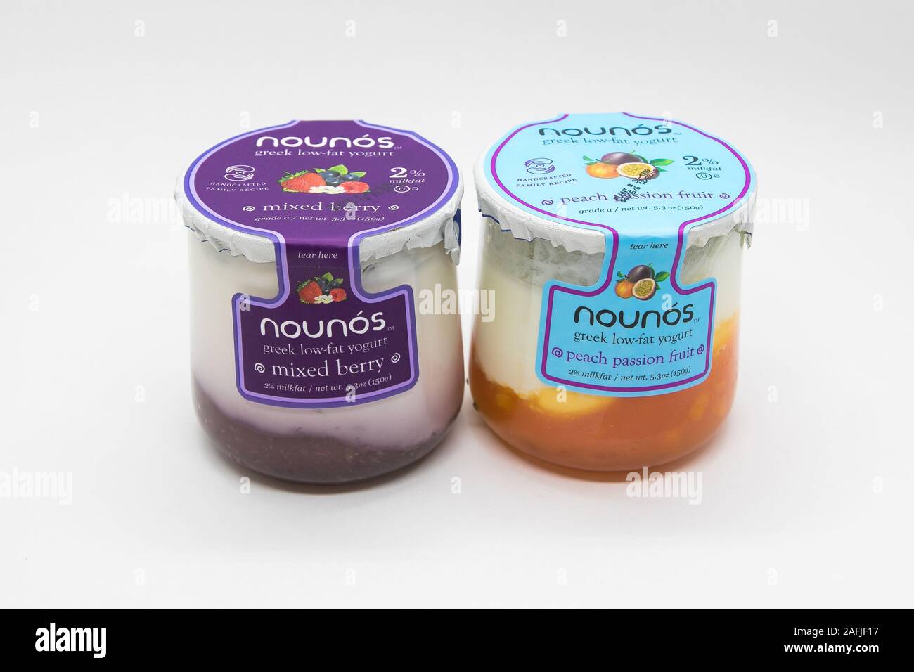 New York, 12/8/2019: Glass containers of Nounos yogurt stand against white background. Stock Photo