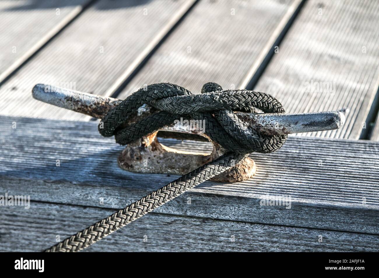 Pier cleat with a rope tied to it. Stock Photo