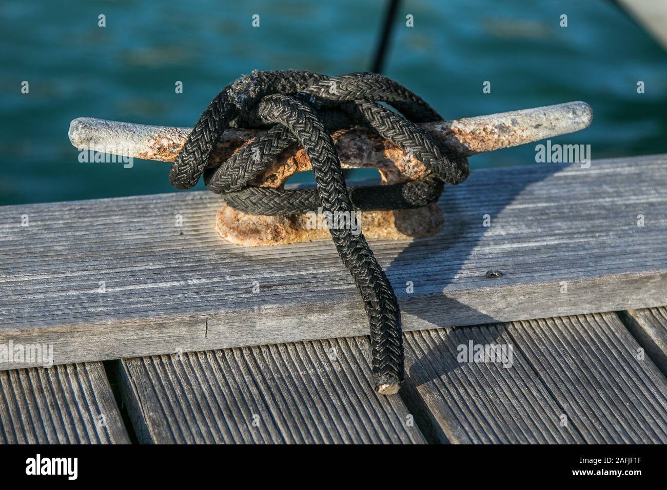 Pier cleat with a rope tied to it. Stock Photo