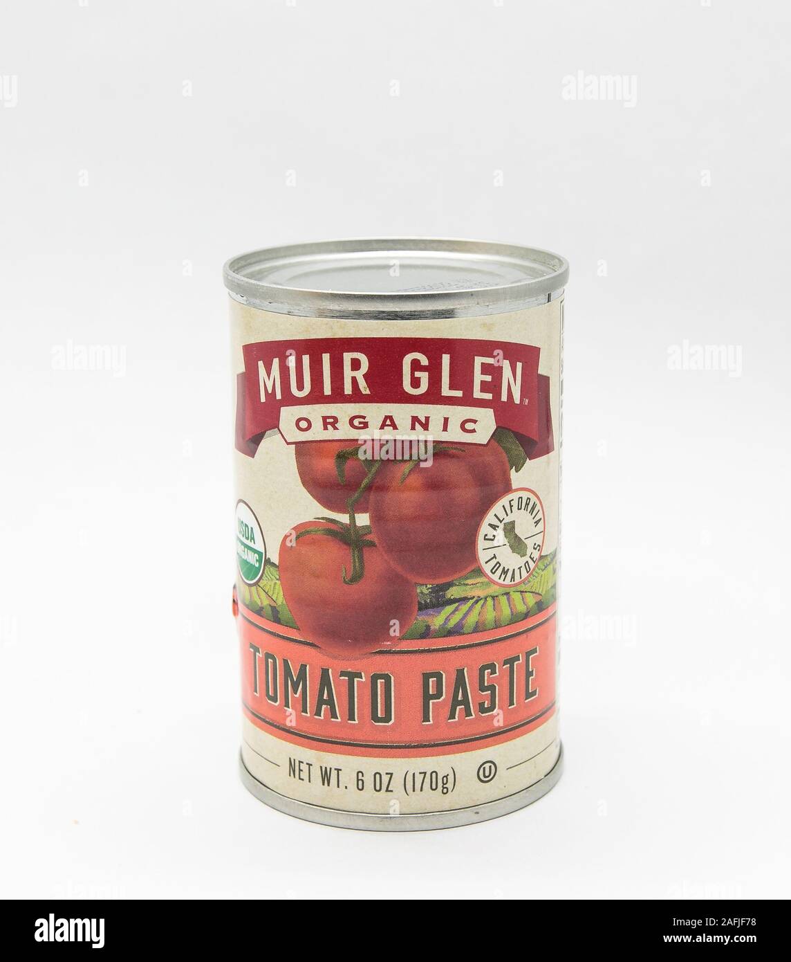 New York, 12/8/2019: Can of Muir Glen tomato paste stands against white background. Stock Photo