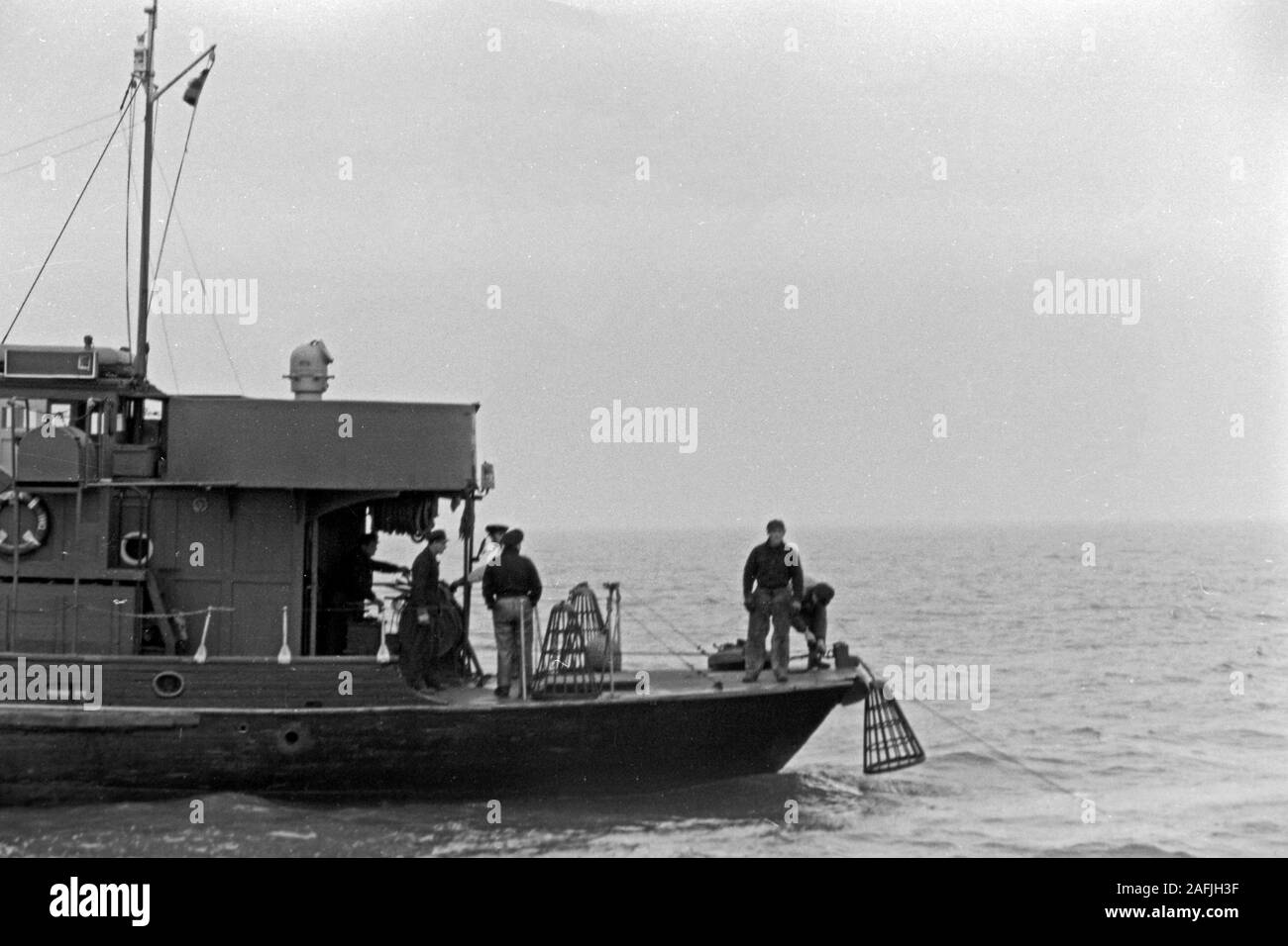 Seeleute setzen Bojen im Hafen von Emden, Niedersachsen, Deutschland 1950. Sailors preparing buoys for watering at Emden harbor, Lower Saxony, Germany 1950. Stock Photo