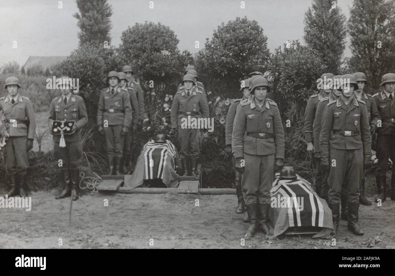 Coffins with flags, orders and German soldiers at a military funeral in