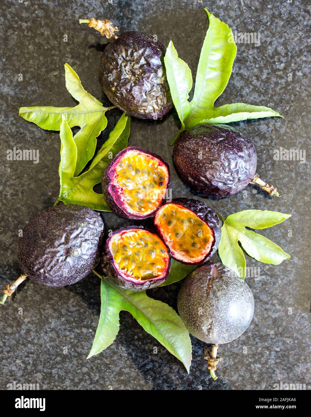 Still live composed of whole and sliced Passion fruit, Passiflora edulis, with leaves Stock Photo