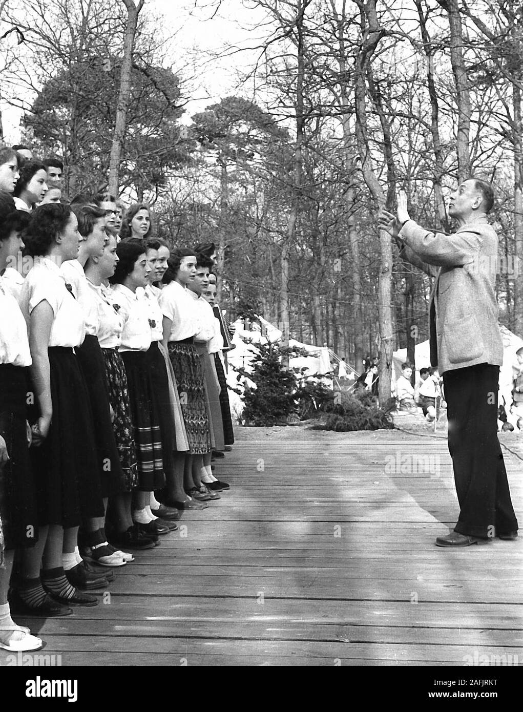 School choir of the Oberschule Fuerstenwalde at the city park Fuerstenwalde on May 1. during a performance. Picture shows the director of the choir and girls singing. Stock Photo
