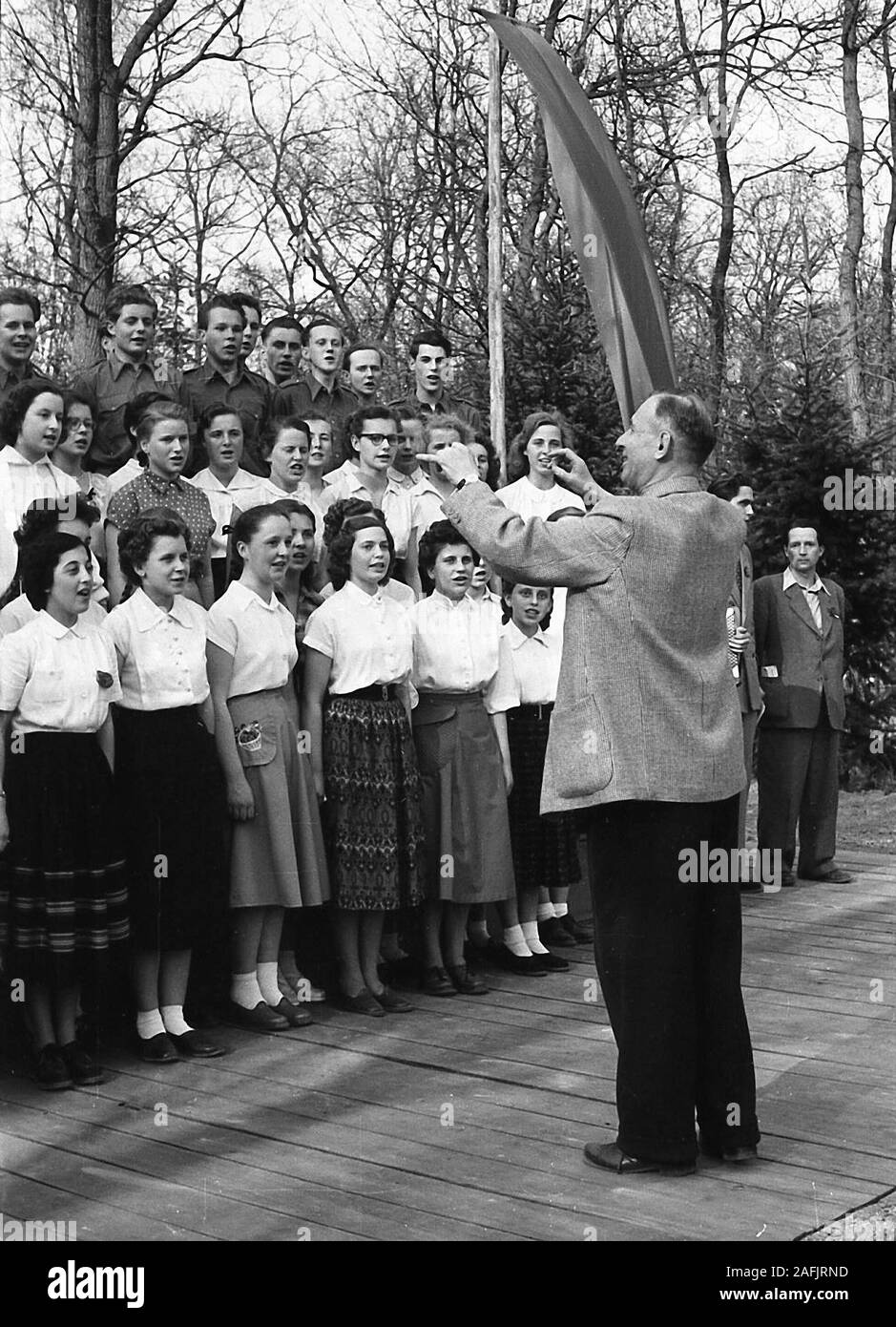 School choir of the Oberschule Fuerstenwalde at the city park Fuerstenwalde on May 1. during a performance. Picture shows the choir director and students singing. Stock Photo