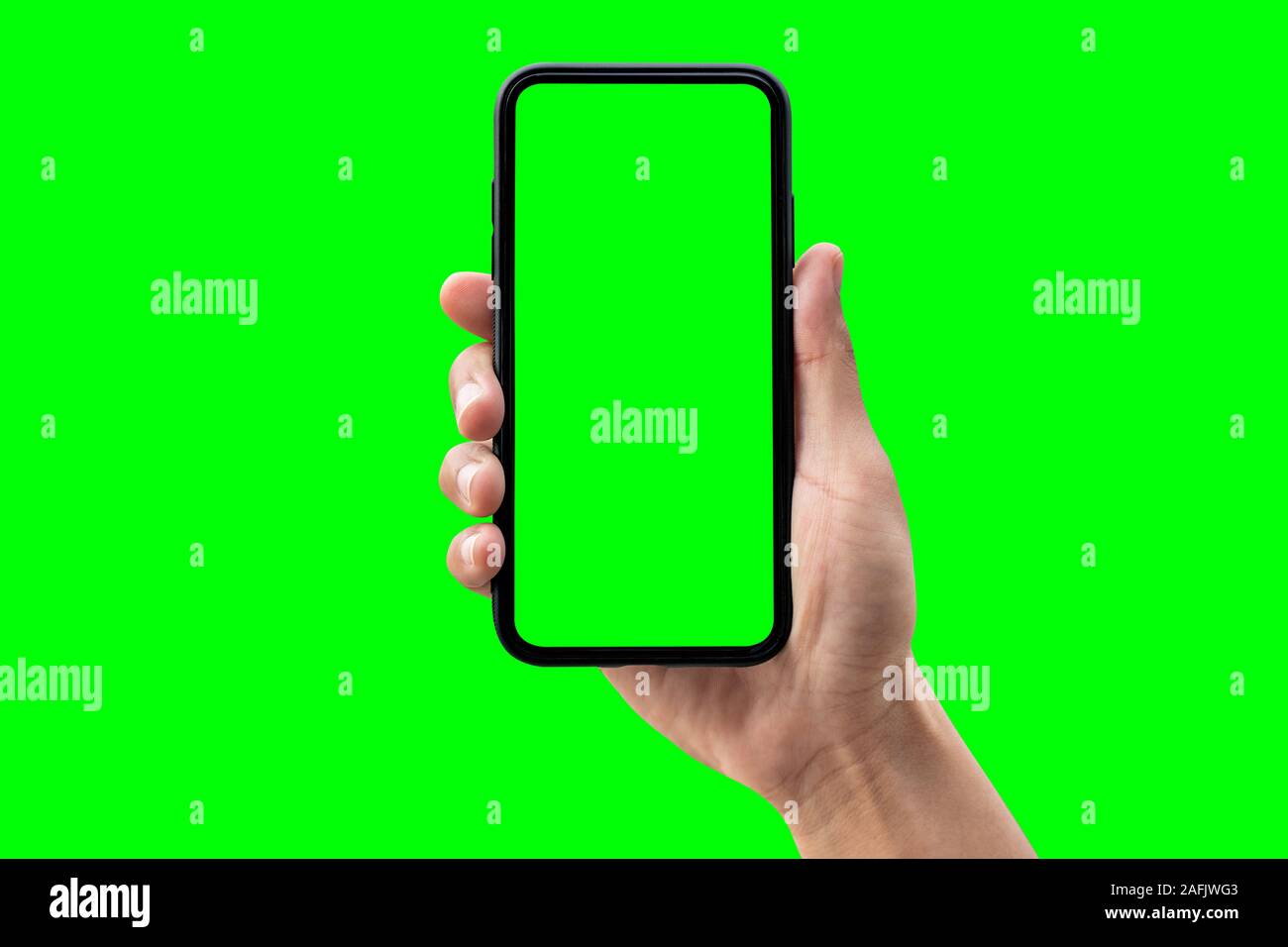 Hand holding smartphone isolated on green background. Stock Photo