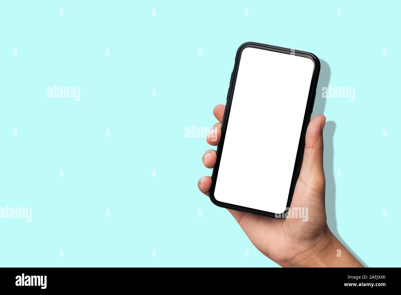 Hand holding smartphone on pastel blue background Stock Photo - Alamy