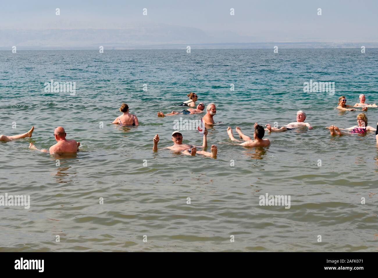 Dead Sea, Jordan - March 05, 2019: Unidentified people enjoy a swim in the salt lake, unsinkable for heavy salinity Stock Photo