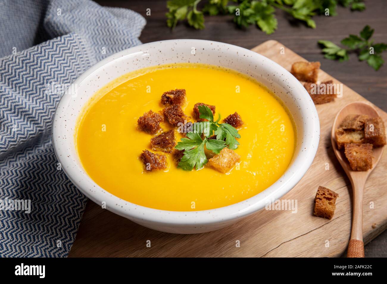 Carrot cream soup with croutons on wooden table. Healthy food Stock Photo