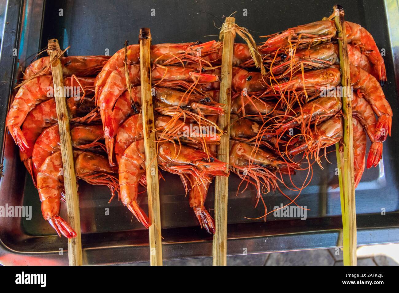 Large prawns barbecued with sticks at stall in the Crab Market at this resort town famous for it's seafood; Kep, Cambodia Stock Photo