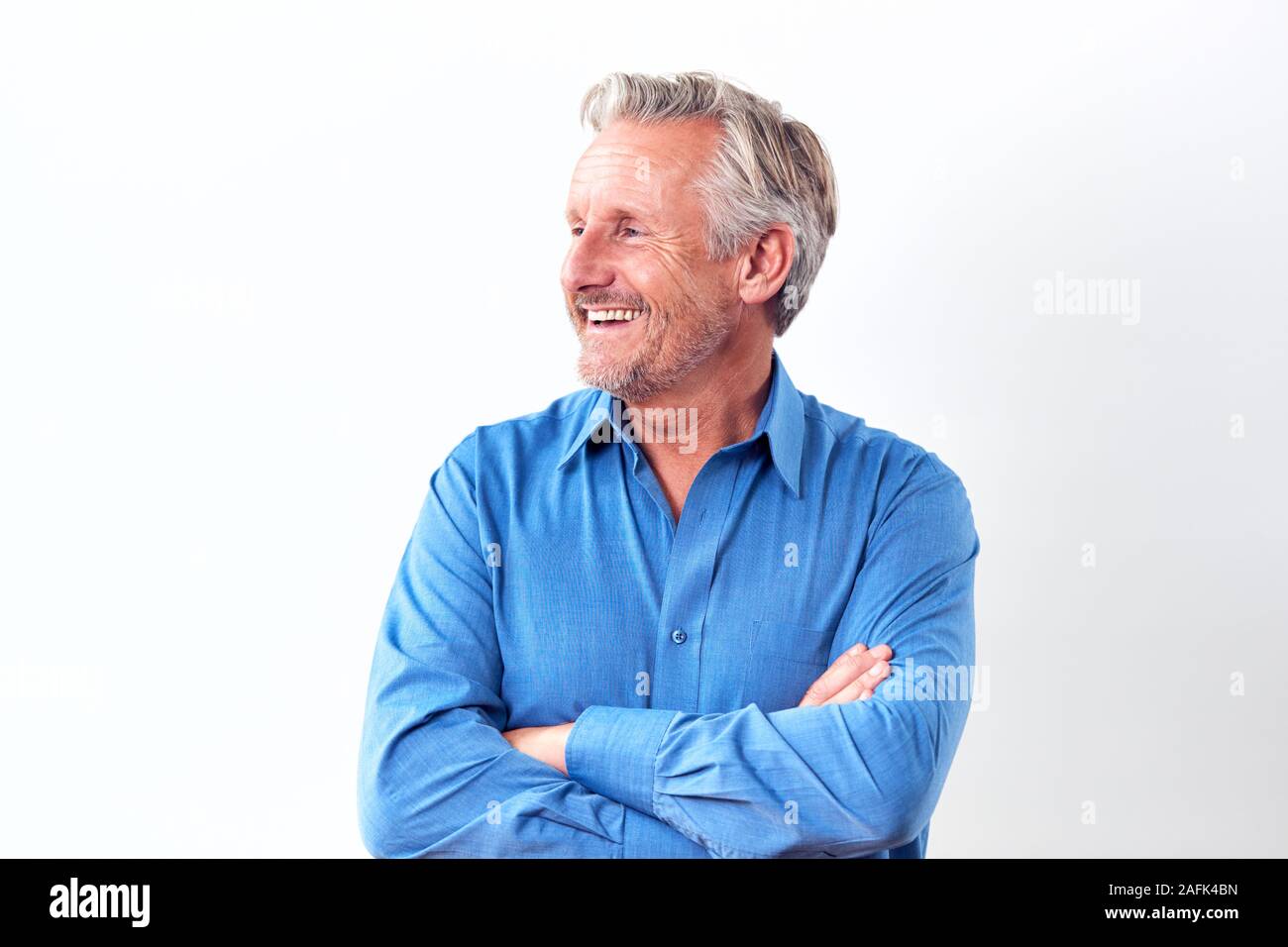 Studio Shot Of Mature Man Against White Background Laughing At Camera Stock Photo