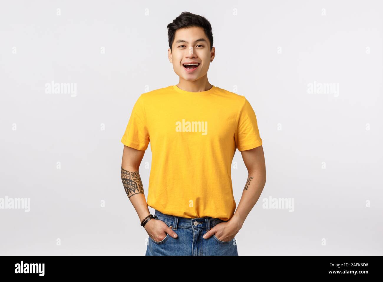 Friendly and joyful, amused good-looking asian guy in stylish yellow t-shirt,  jeans, hold hands in pockets, smiling and laughing at funny movie Stock  Photo - Alamy