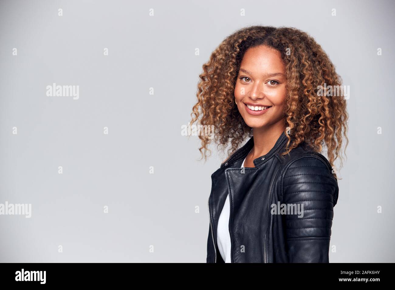 Offset Studio Portrait Of Happy Young Woman Wearing Leather Jacket Smiling At Camera Stock Photo