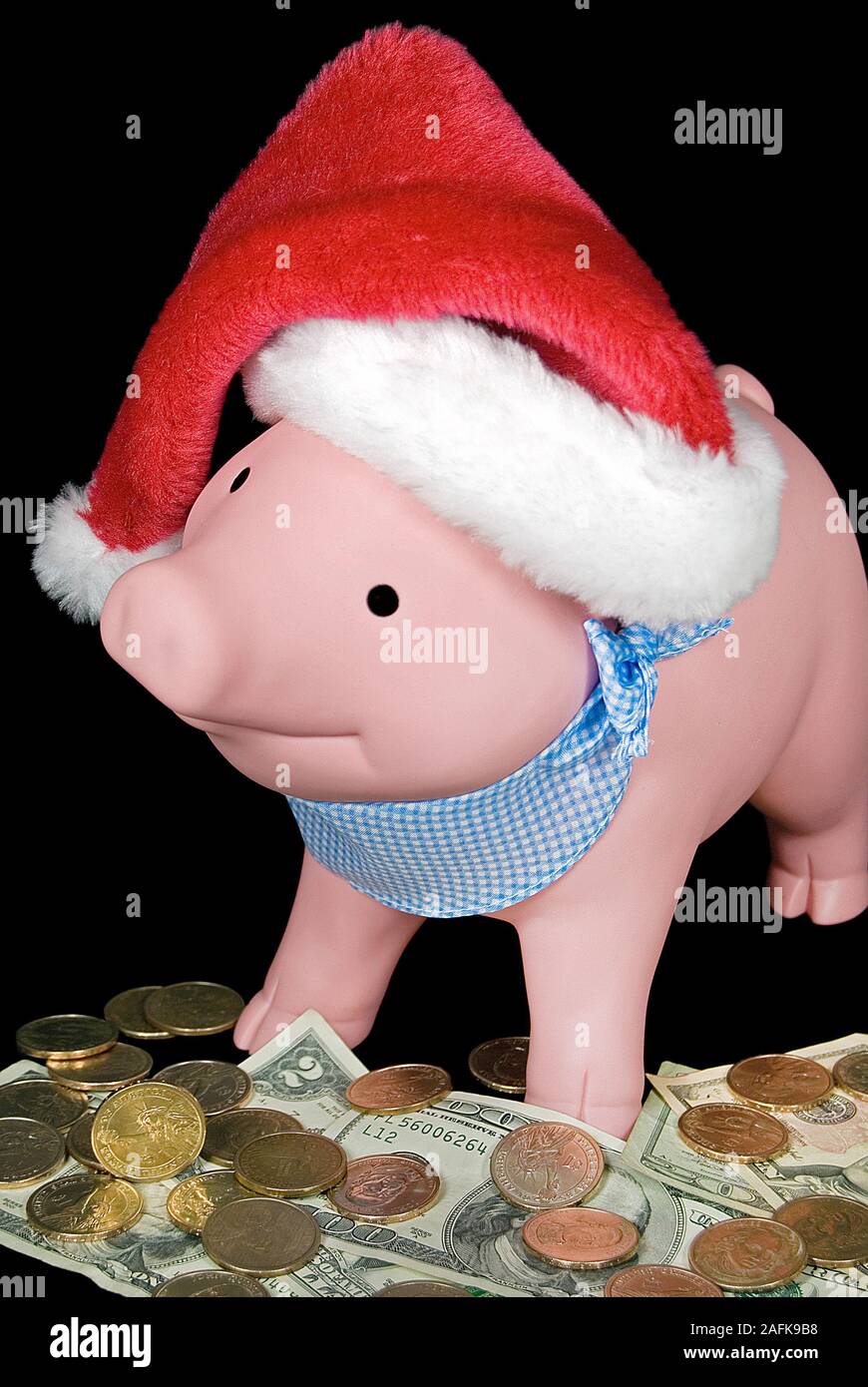 pink pig with Christmas Santa cap on American money Stock Photo