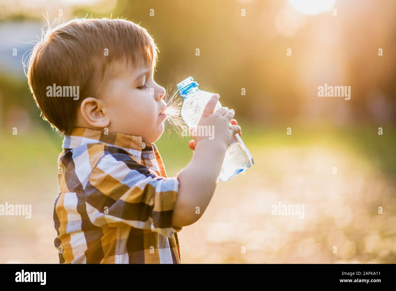 the boy drank water from a bottle and choked Stock Photo Alamy