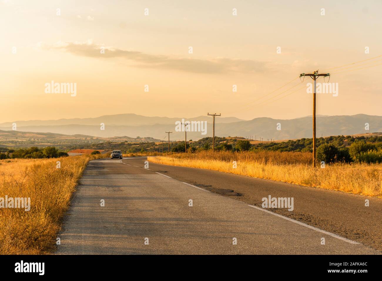 Car on the road and fields in Greece horizontal Stock Photo