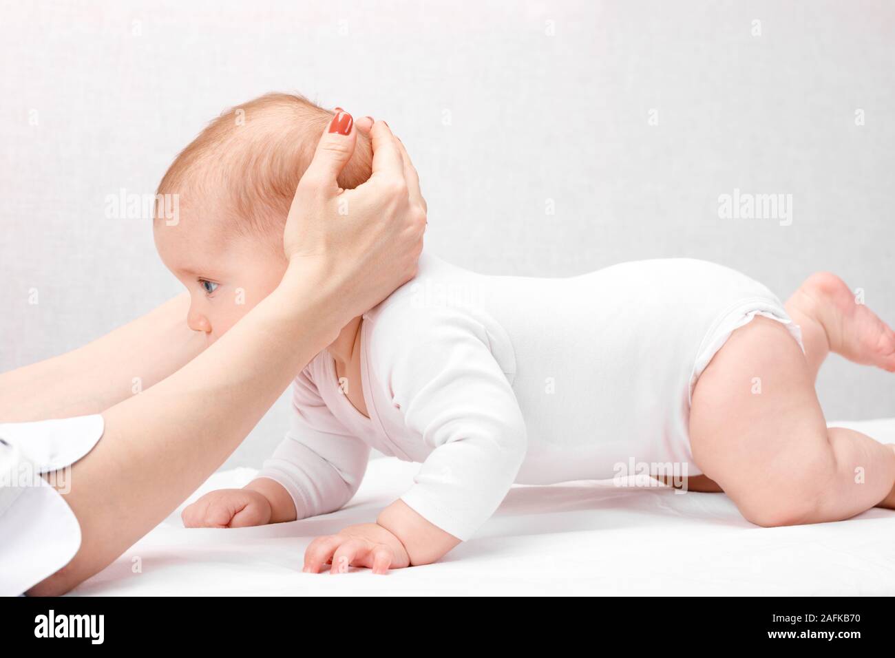 Six month baby girl receiving osteopathic or chiropractic treatment in