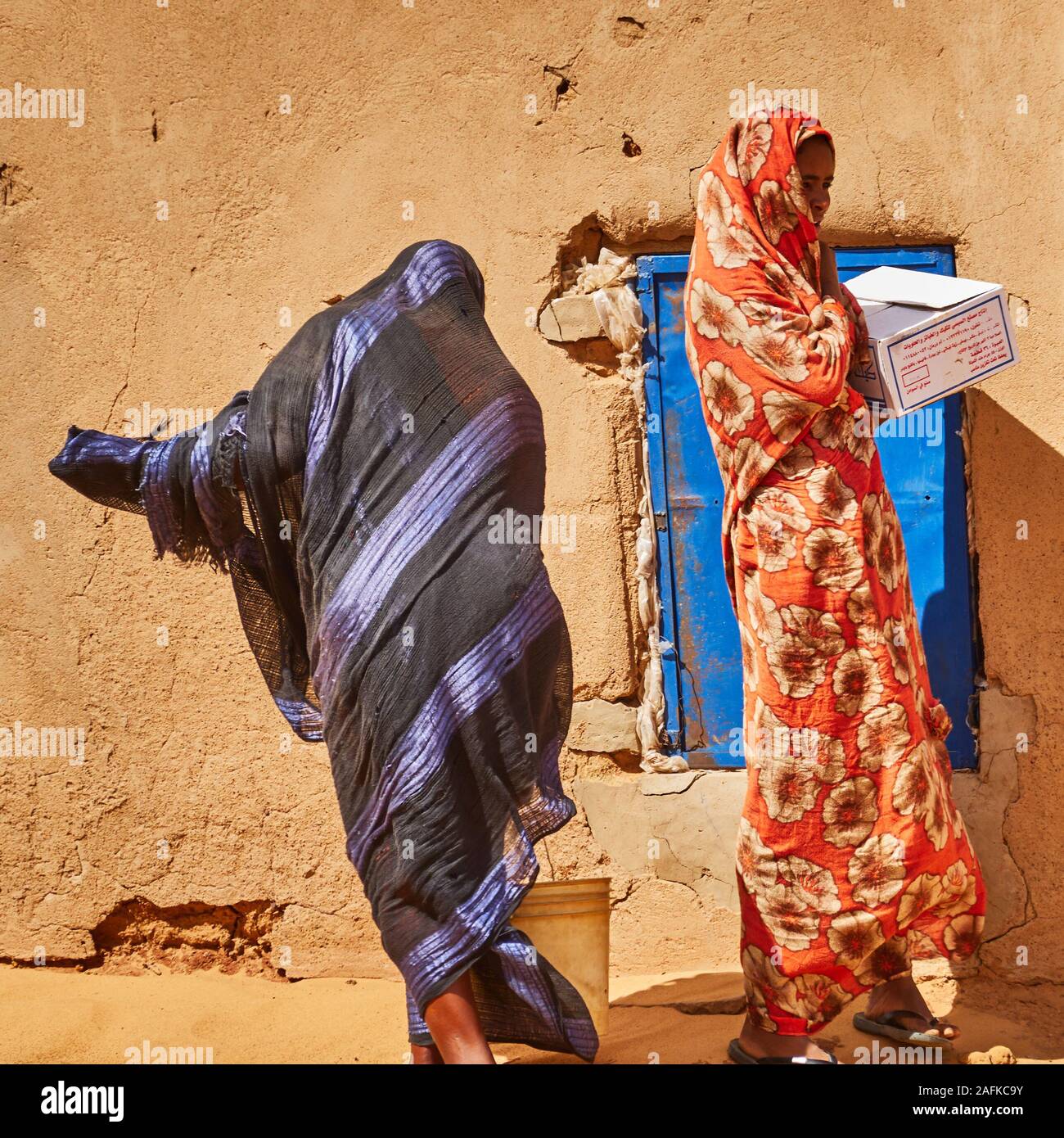 Khartoum, Sudan, ca. February 8., 2019: Sudanese women in typical Sudanese clothes shopping in a small village in the desert Stock Photo