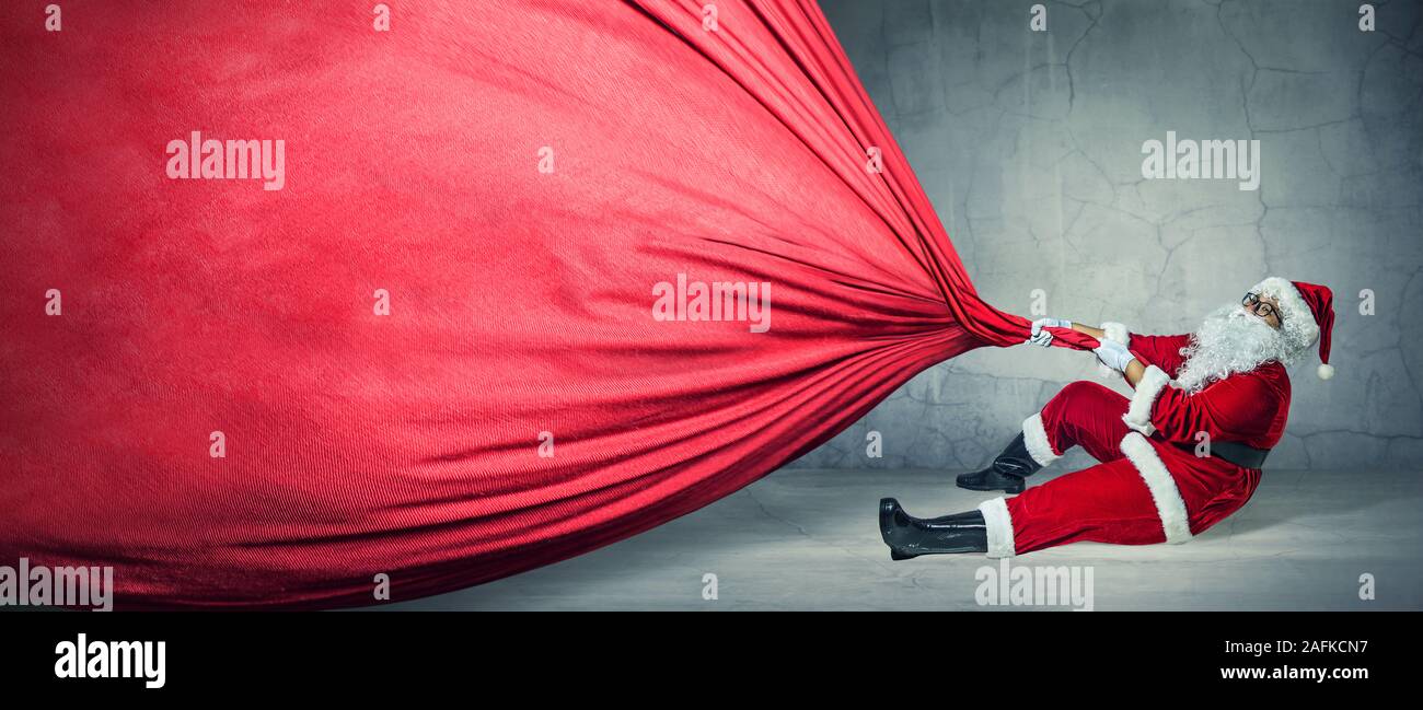 Santa Claus with big bag on blank advertisement banner with copy space. Christmas theme, sales - Image Stock Photo