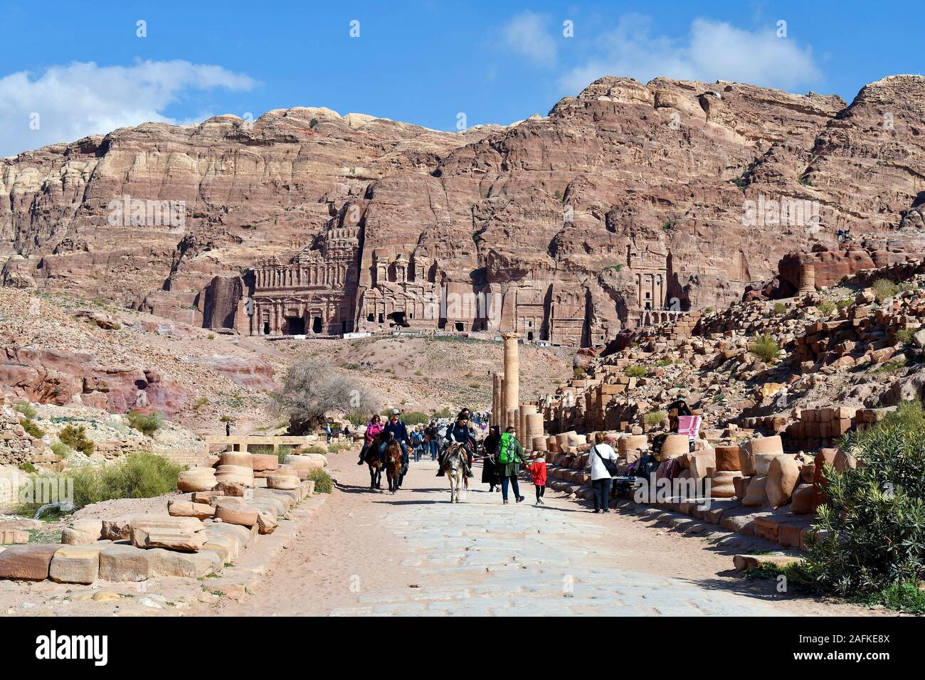 Petra, Jordan - March 06, 2019: Unidentified people in UNESCO World heritage site of ancient Petra on colonnadfed street with royal tombs in backgroun Stock Photo
