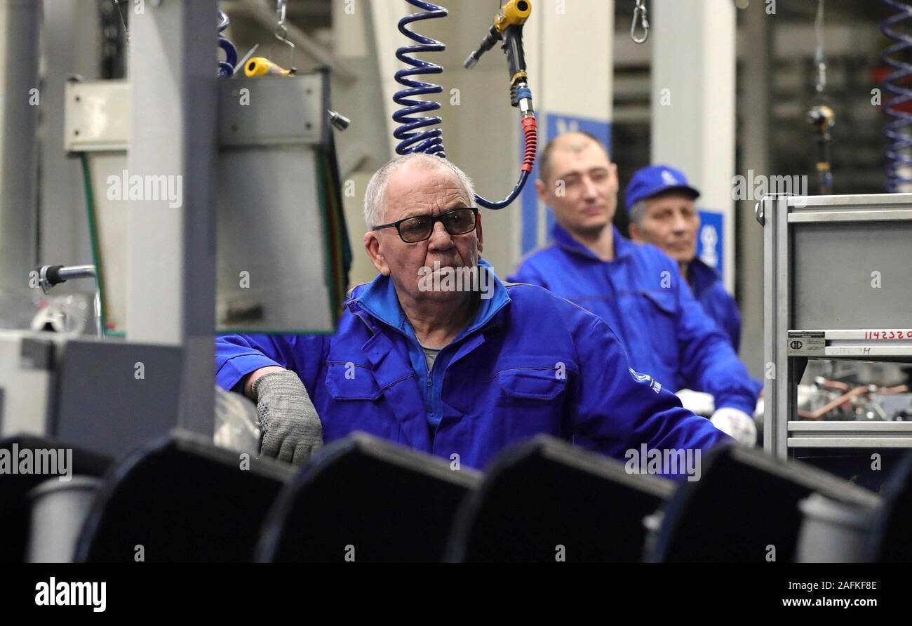 Assembly line workers look on as Russian President Vladimir Putin tours the Daimler KAMAZ Rus engine and truck frame joint venture commercial vehicle plant December 13, 2019 in Naberezhnye Chelny, Tatarstan, Russia. Stock Photo