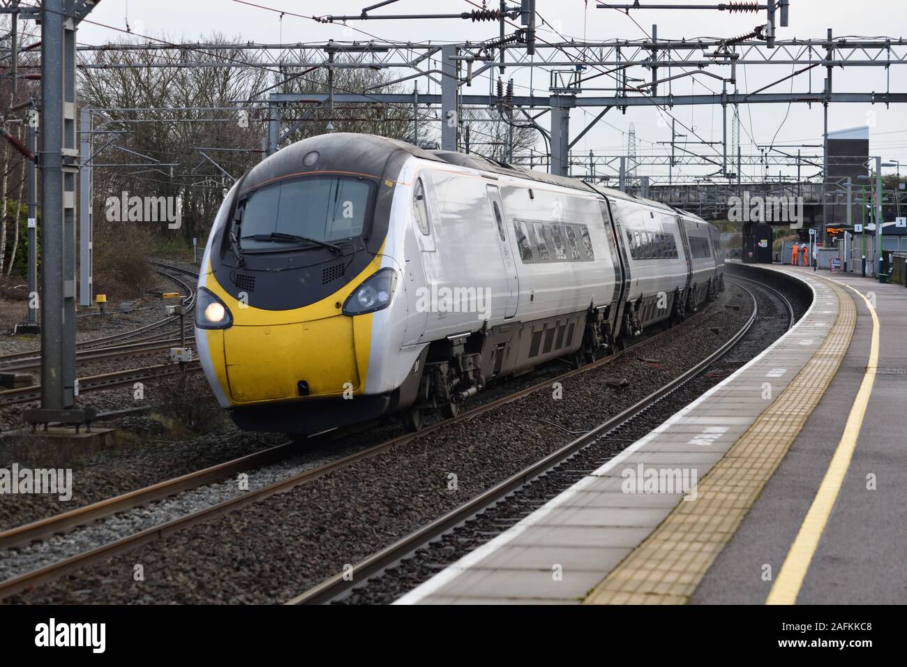 Avanti West Coast 9 car Pendolino 390013 rushes through Lichfield Trent Valley with 1F15 the 11:07 London Euston to Liverpool  on 16 December 2019 Stock Photo