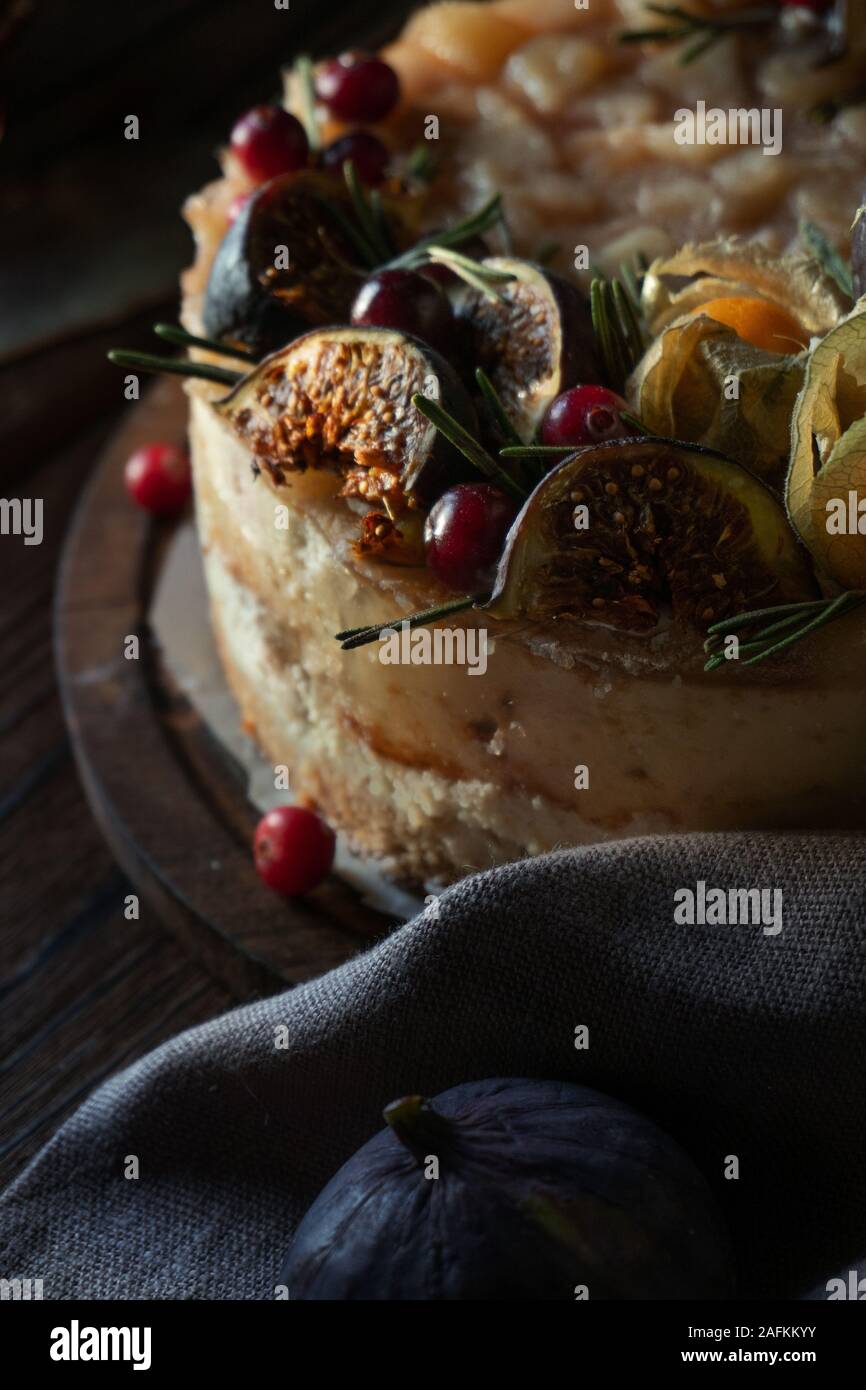 Cheesecake with physalis and dates on a wooden stand close up Stock Photo