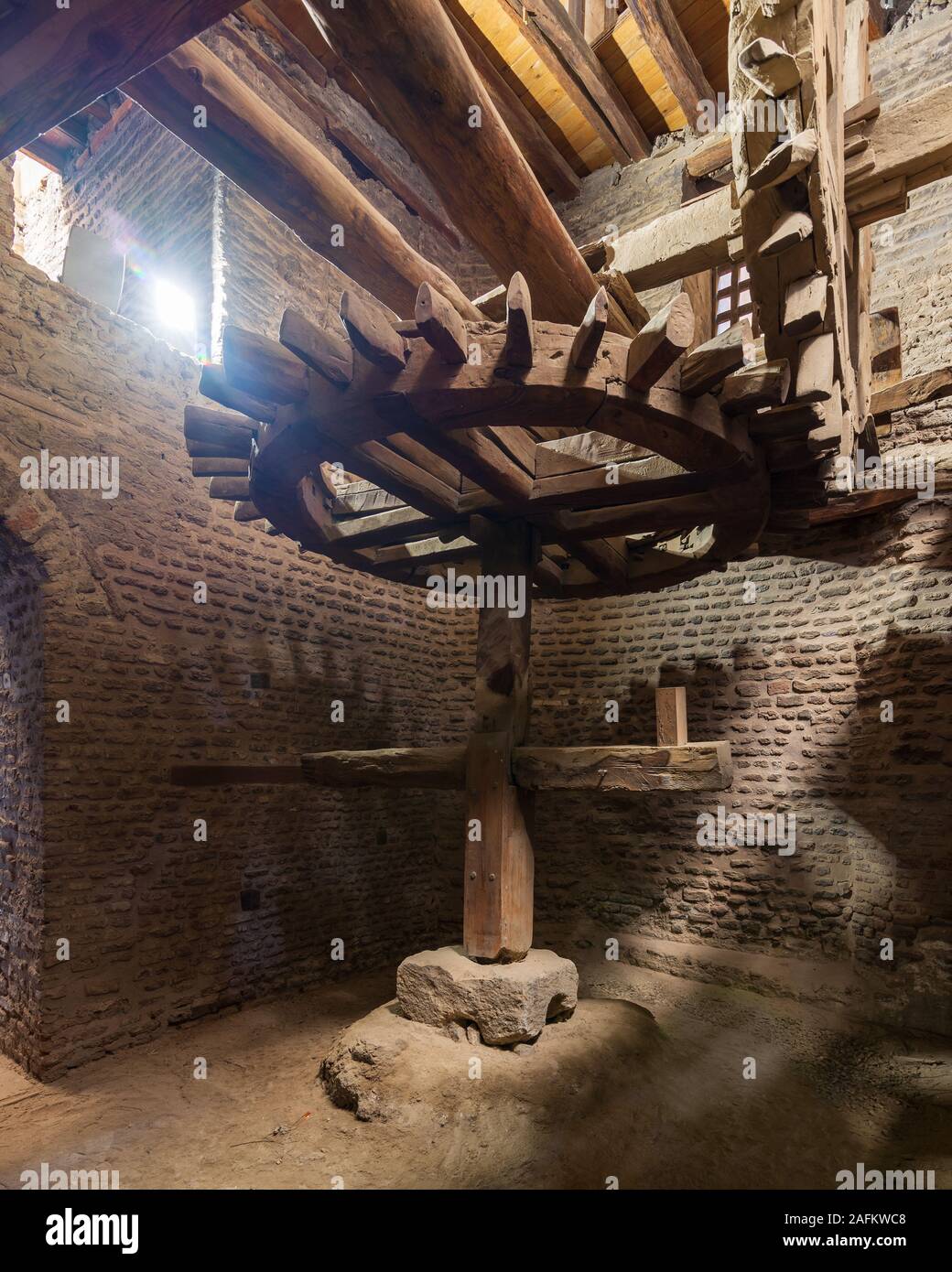 Aged water mill turning inside weathered mill building at Amir Taz