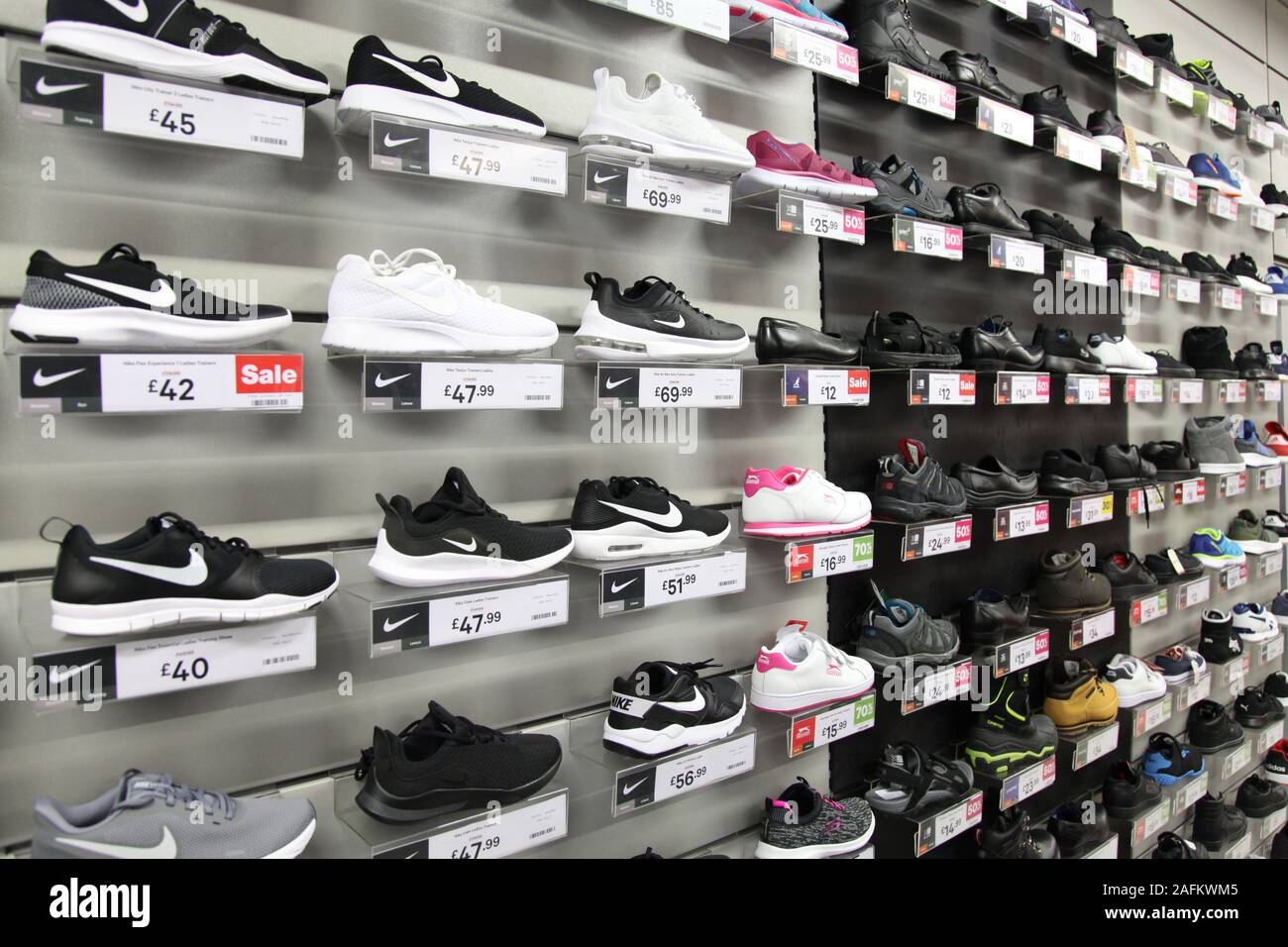 A display wall of mens trainers with prices at JD Sports shop, 2019 Stock Photo