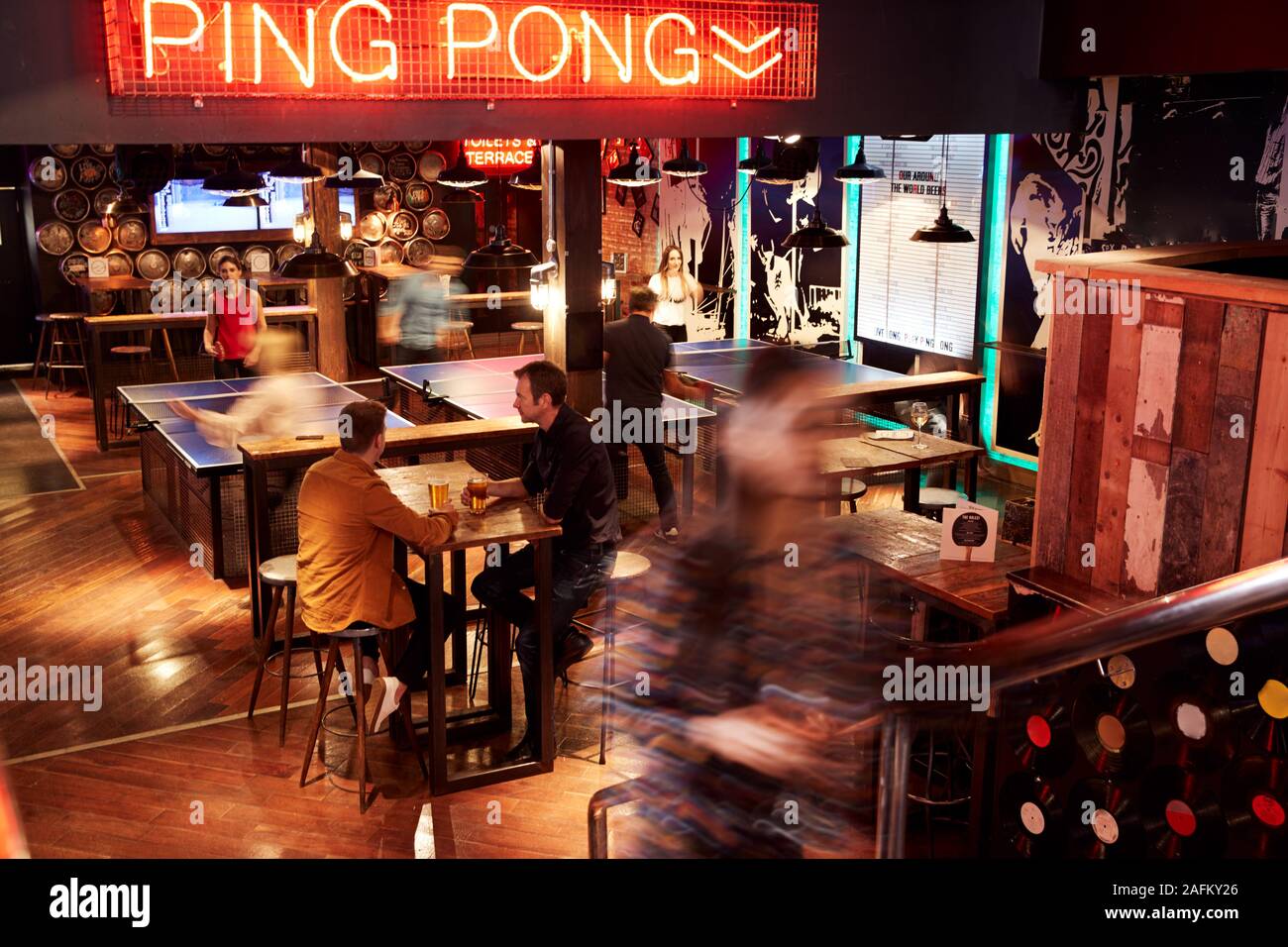 Interior Of Bar With Customers Drinking And Playing Table Tennis Stock