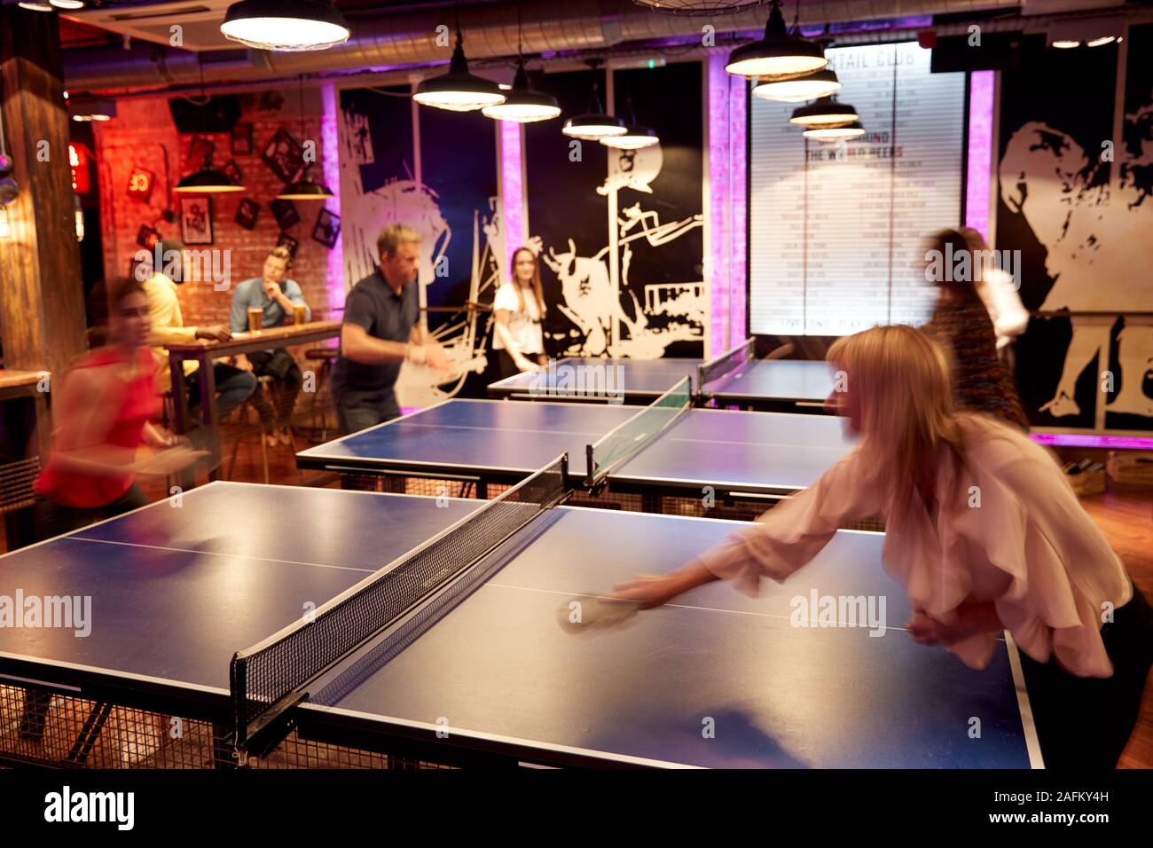 Interior Of Bar With Customers Drinking And Playing Table Tennis Stock