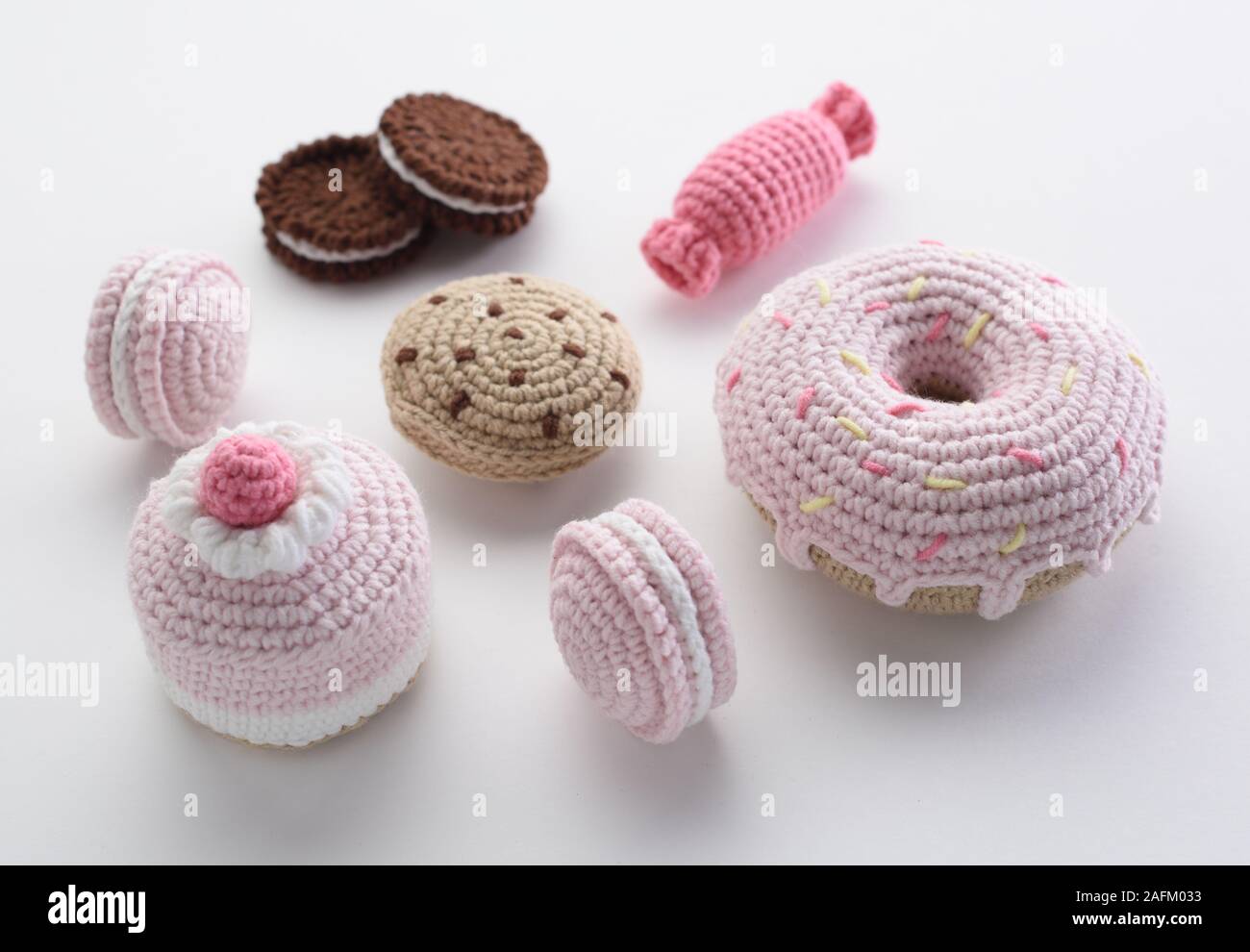 Handmade knitted toys. Cute amigurumi pink and chocolate buns, cookies,  macarons and donut toys. Crochet miniature stuffed sweets on white  background Stock Photo - Alamy